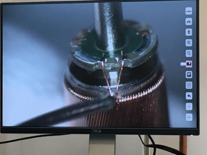 Soldering the impeller motor connections under a microscope. Impella being made at the Abiomed factory.
