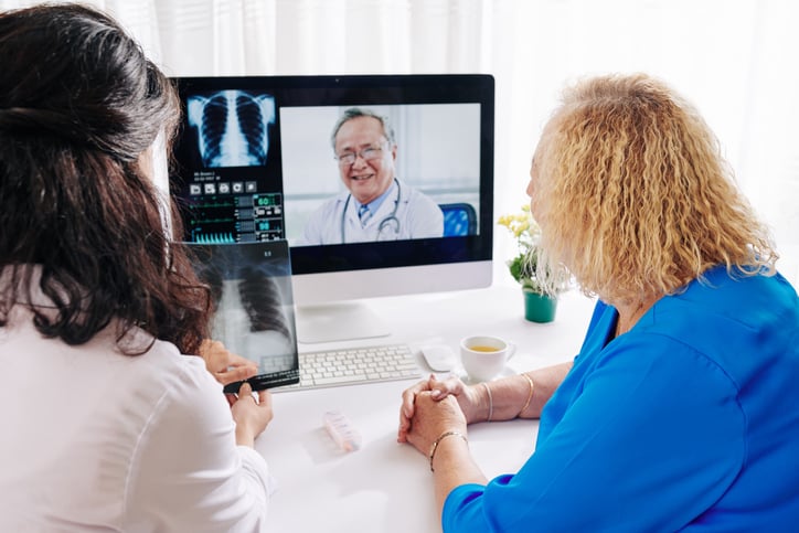 An example of patient and physician interfacing with a radiologist through an online video meeting and looking at their teleradiology images.  Getty Images