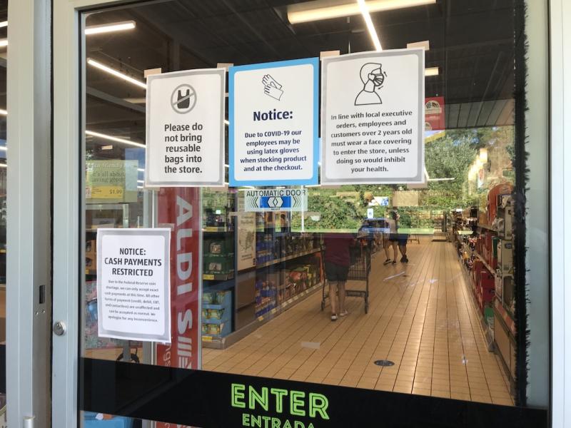 COVID-19 related warnings at the entrance to an Aldi grocery store in Elgin, Illinois, outside of Chicago. Photo by Dave Fornell 