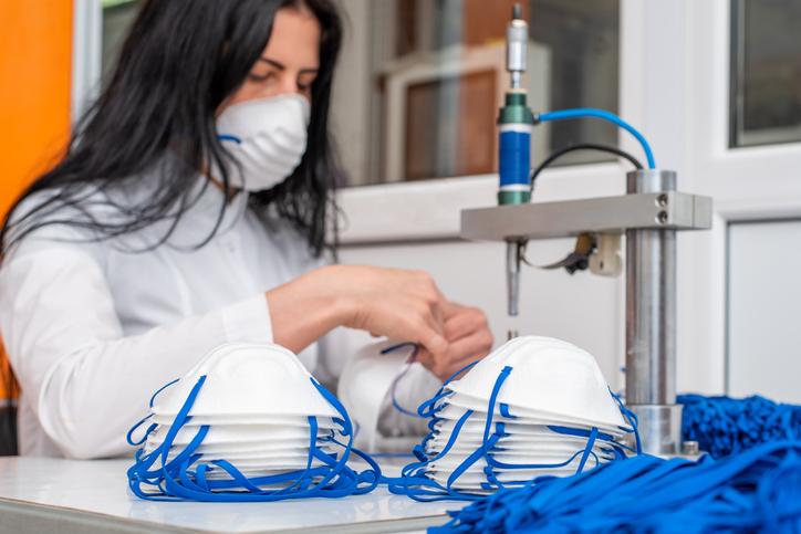 A woman works at a machine for the manufacture of medical masks with nanofibre and solder ear loops to them with ultrasound. The first wave of coronovirus caused a massive shortage of personal protective equipment (PPE). This lead to the U.S. originally discouraging mask wearing to allow what supplies were available to go to hospitals. The FDA approved reusing and sterilizing N95 masks for reuse by healthcare workers. Supplies began to catch up to demand by the summer and fall of 2020.