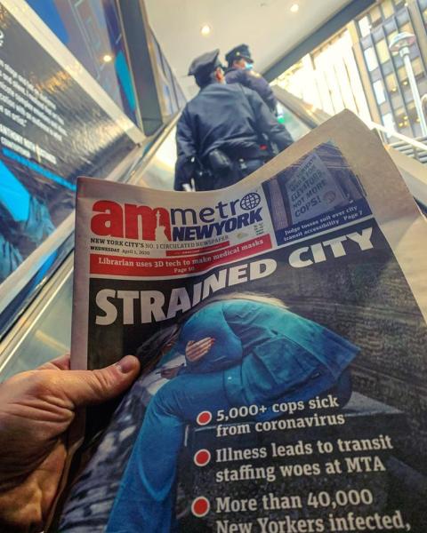 A New York City newspaper headlines echo clearly on an escalator from the subway with New York Police officers April 1. First responders and healthcare workers have become the heroes of the NYC COVID-19 response. Photo by Mike Borchardt.