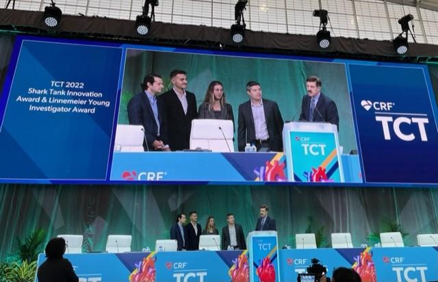 Representatives from Puzzle Medical Devices accept the TCT 2022 Innovation Shark Tank Competition Award from CRF President and CEO Juan F. Granada and Robert Schwartz, MD, President of the Jon DeHaan Foundation for Medical Innovation, which sponsors the award.