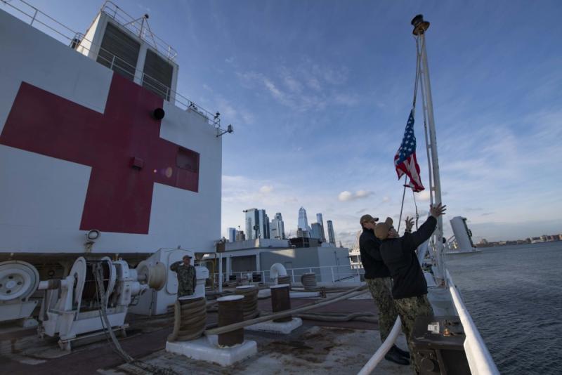 Sailors participate in a morning colors ceremony aboard the hospital ship USNS Comfort (T-AH 20) while the ship is moored in New York City in support of the nation’s COVID-19 response efforts. Comfort was supposed to serve as a referral hospital for non-COVID-19 patients currently admitted to shore-based hospitals. However after criticism the ship treated very few patients it will be opened up to treat COVID-19 patients. U.S. Navy photo by Mass Communication Specialist 2nd Class Sara Eshleman