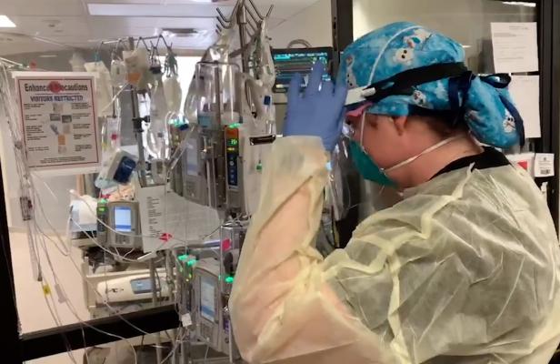 A nurse at Banner Health ion Phoenix, Ariz., adjusts an ECMO unit being used to support a severely ill COVID-19 patient. A new study finds high levels of moral distress among clinicians who regularly care for patients receiving mechanical circulatory support such as ECMO.