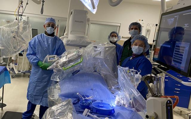 Christopher Baker, M.D., and his team perpare to perform their first robotically navigated carotid artery stenting procedure at Hoag Memorial Hospital Presbyterian. The Corindus Corpath robotic system can be seen over the patient on the table.