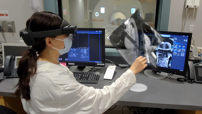A composite photo demonstrating how mixed reality visualization would be combined with robotic surgery in an MRI. 