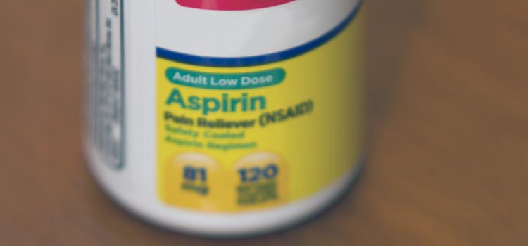 Closed low dose Asprin bottle surrounded by tablets